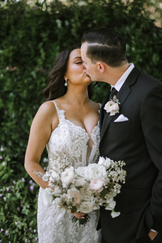 bride and groom kissing during wedding photos