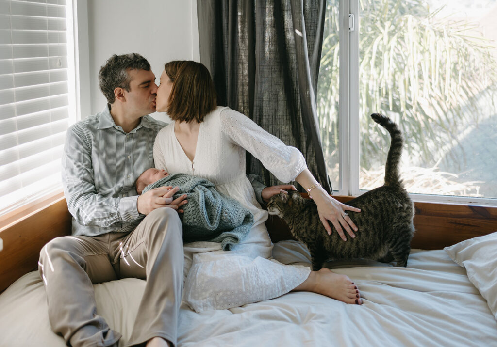 couples kissing during their in home newborn session