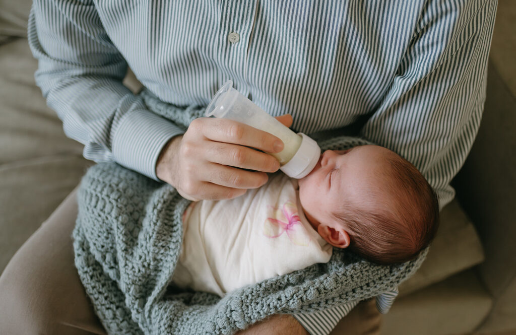 dad feeding his baby during the in home photoshoot