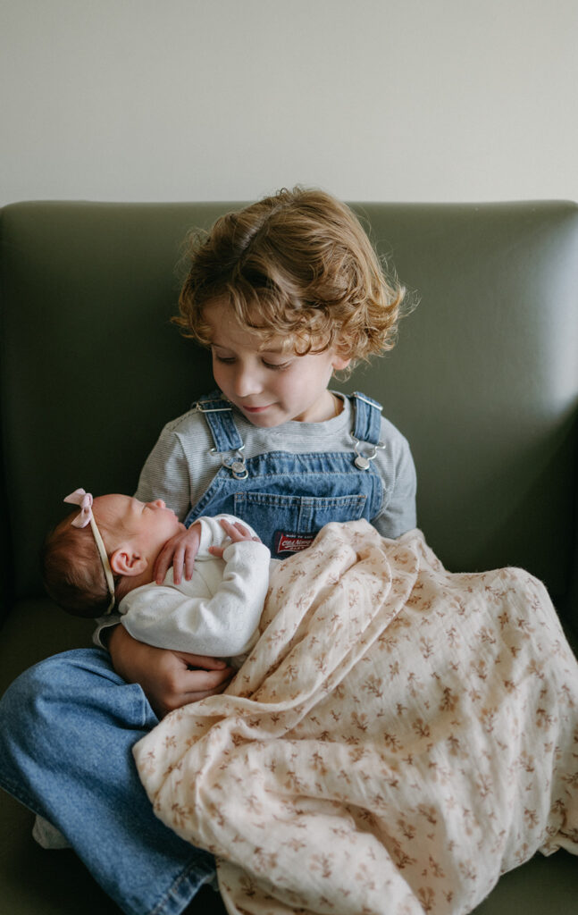 brother holding his newborn sister 